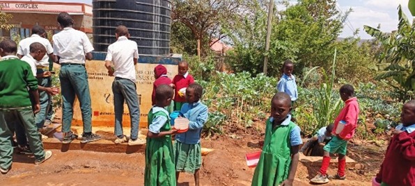 Pupils enjoying a drink from borehole water